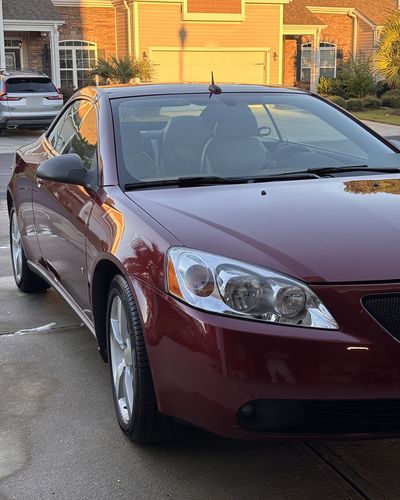 Red Pontiac G6 convertible, front three-quarter view in a driveway